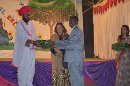 Guest of honour receiving memento from Principal and viceprincipal